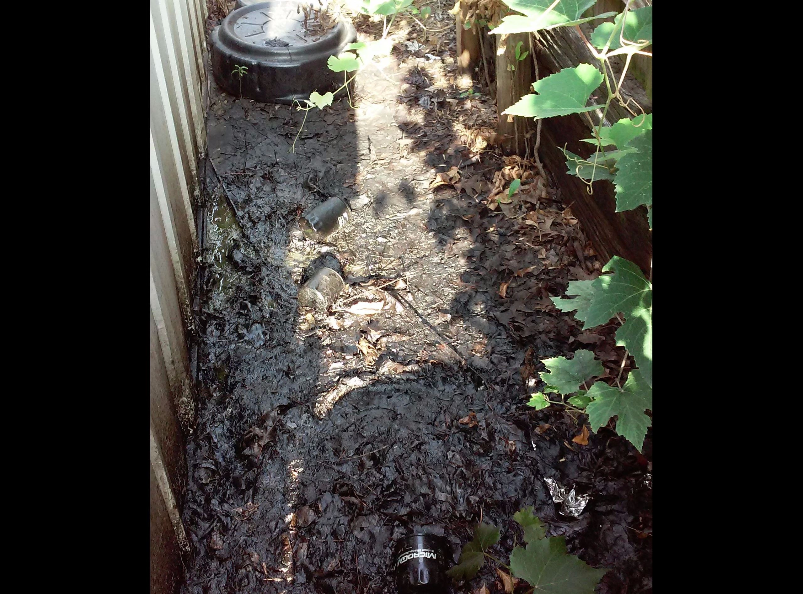 A dirty water pipe rests in the dirt